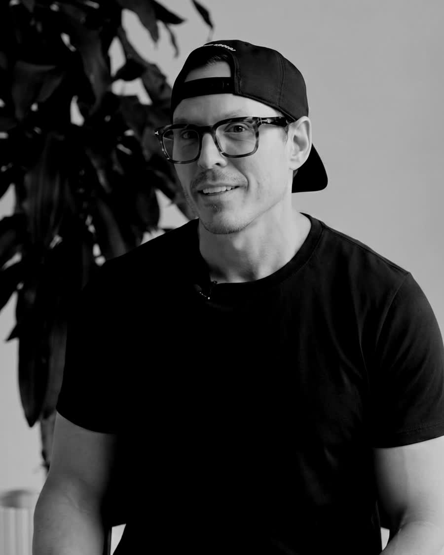 Dr. Michael Webster, wearing a backwards cap and glasses, in black and white.