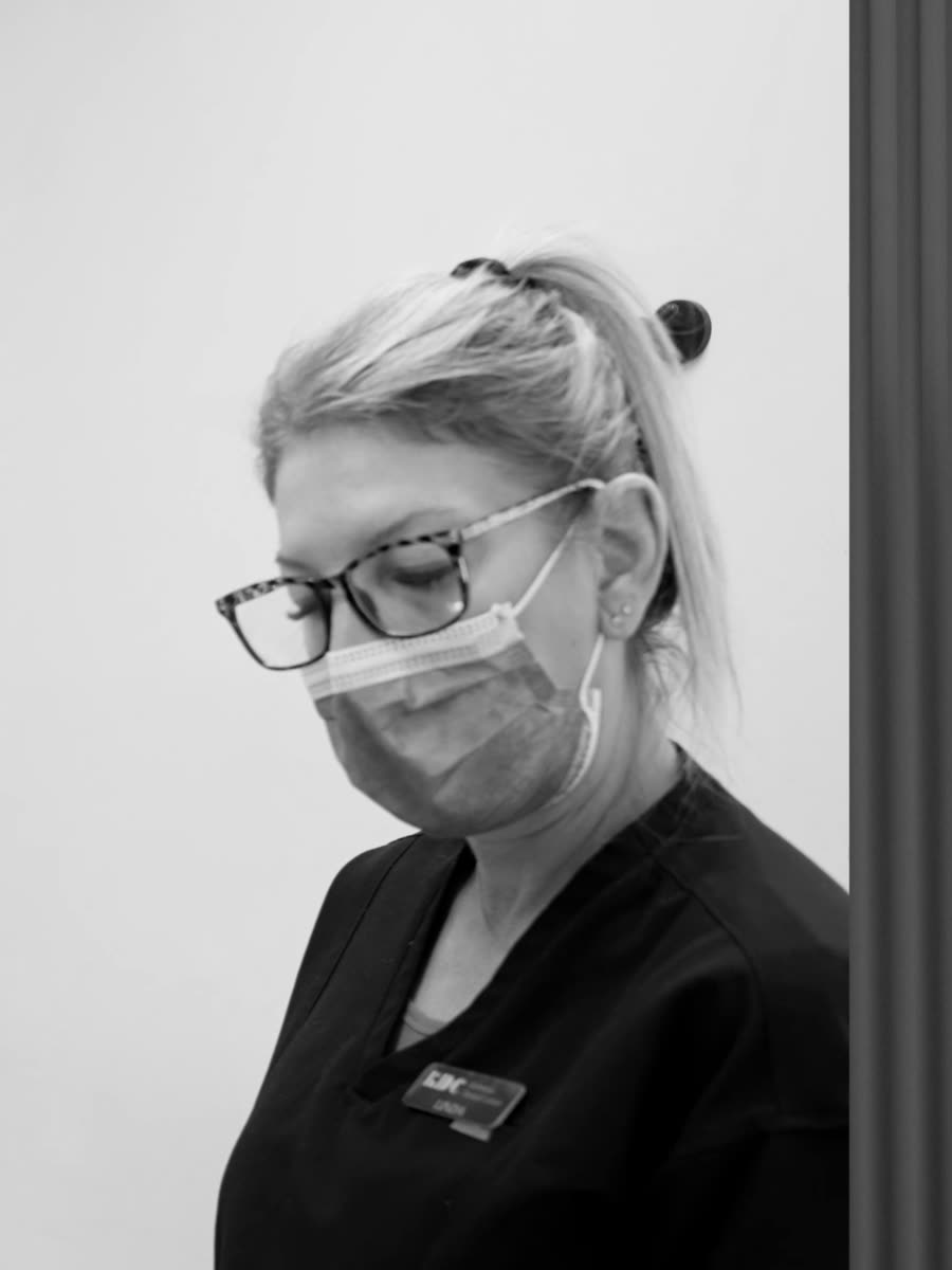 A team member in scrubs and mask.